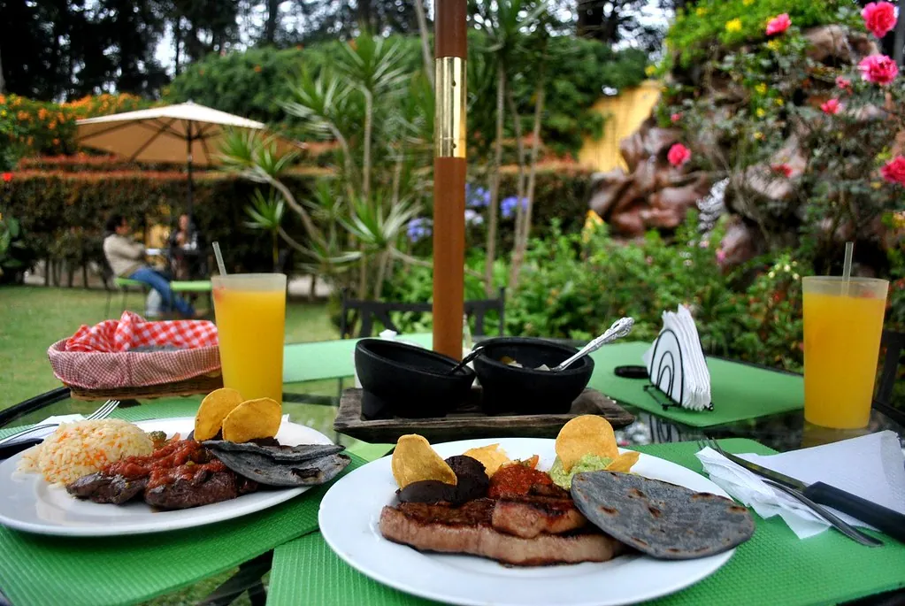 Mesa de desayuno con jugos, café y platos para compartir